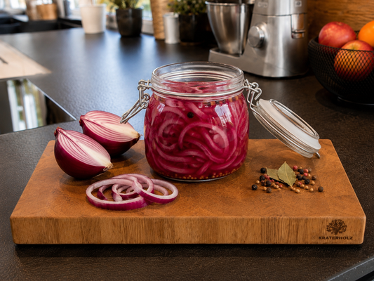 Rote Zwiebeln eingemacht in Glas auf Schneidebrett 