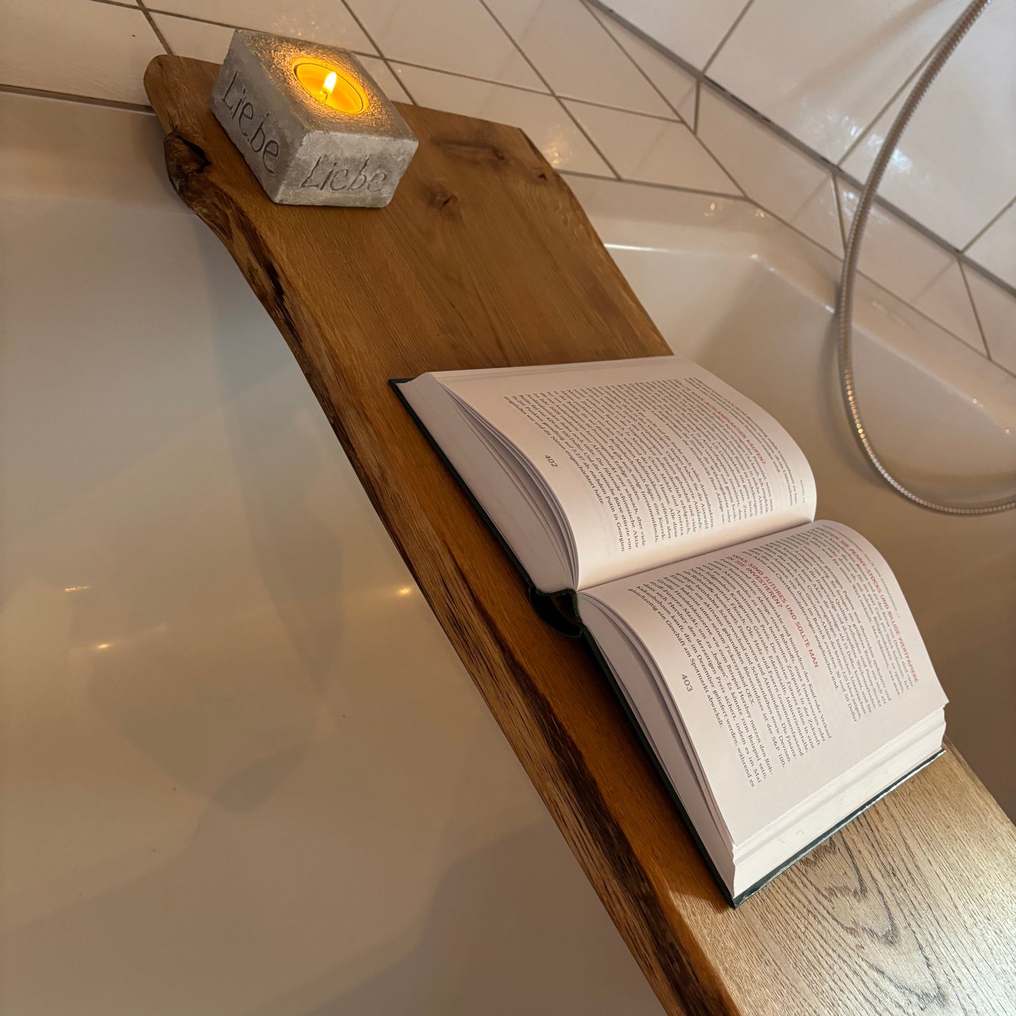 Badewannenbrett mit Kerze und Buch auf Badewanne