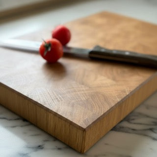 Schneidebrett auf Marmor mit Messer und Tomaten